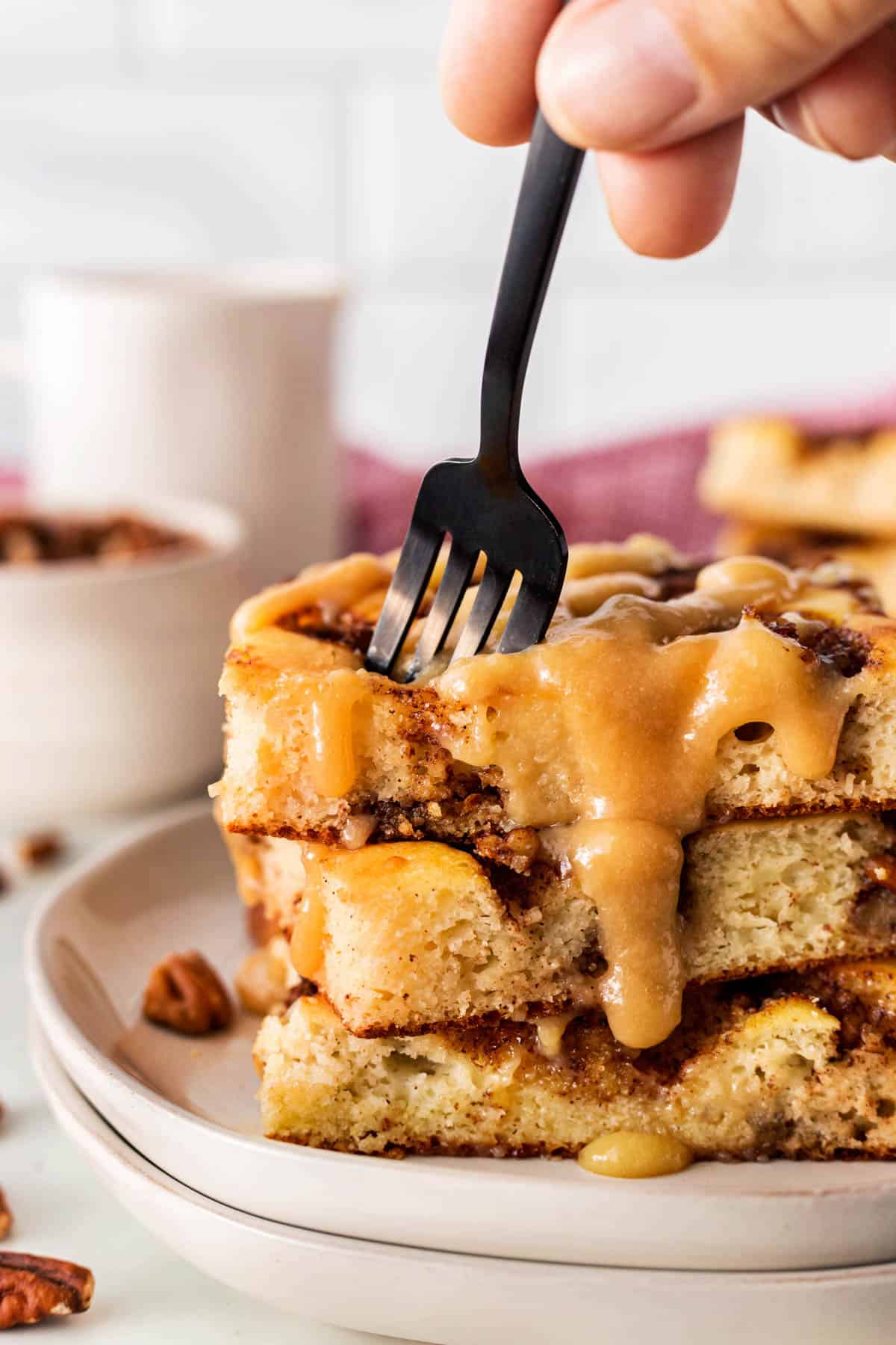 Sticking a fork into a stack of sheet pan pancakes. 